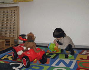 Kind und Kuschelaffe mit Auto